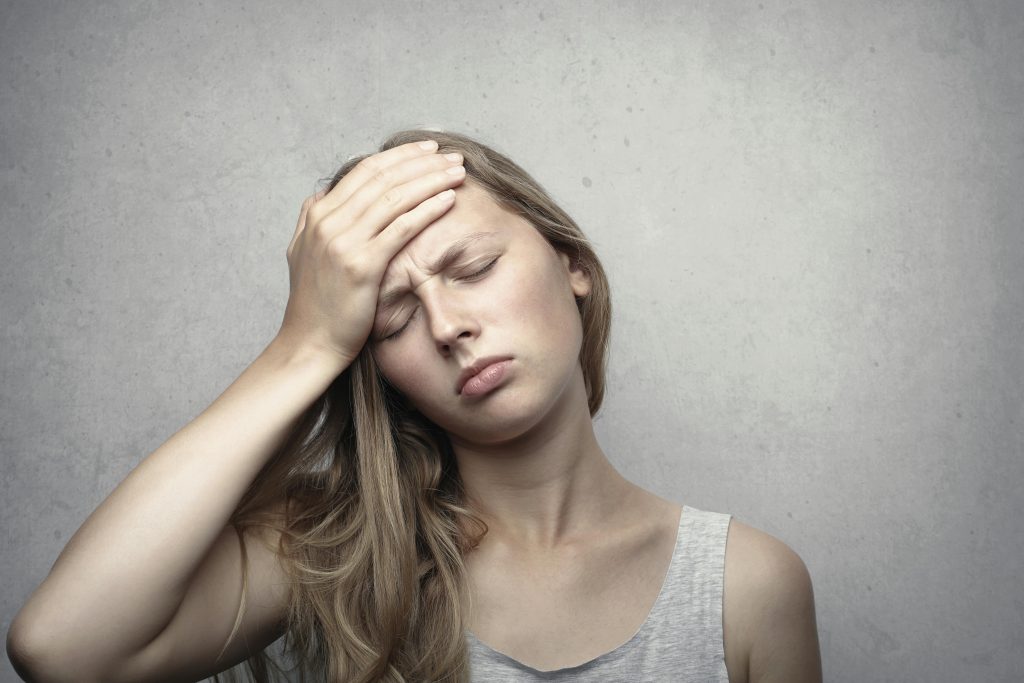 Woman holding her head with a look of discomfort