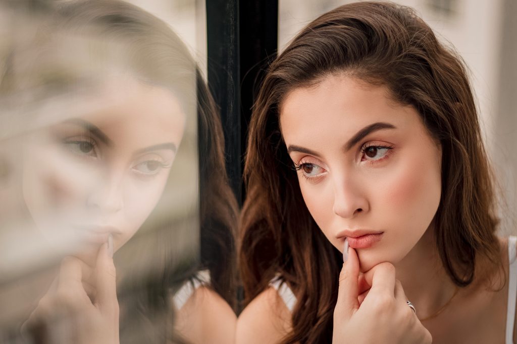Woman looking out a window thinking